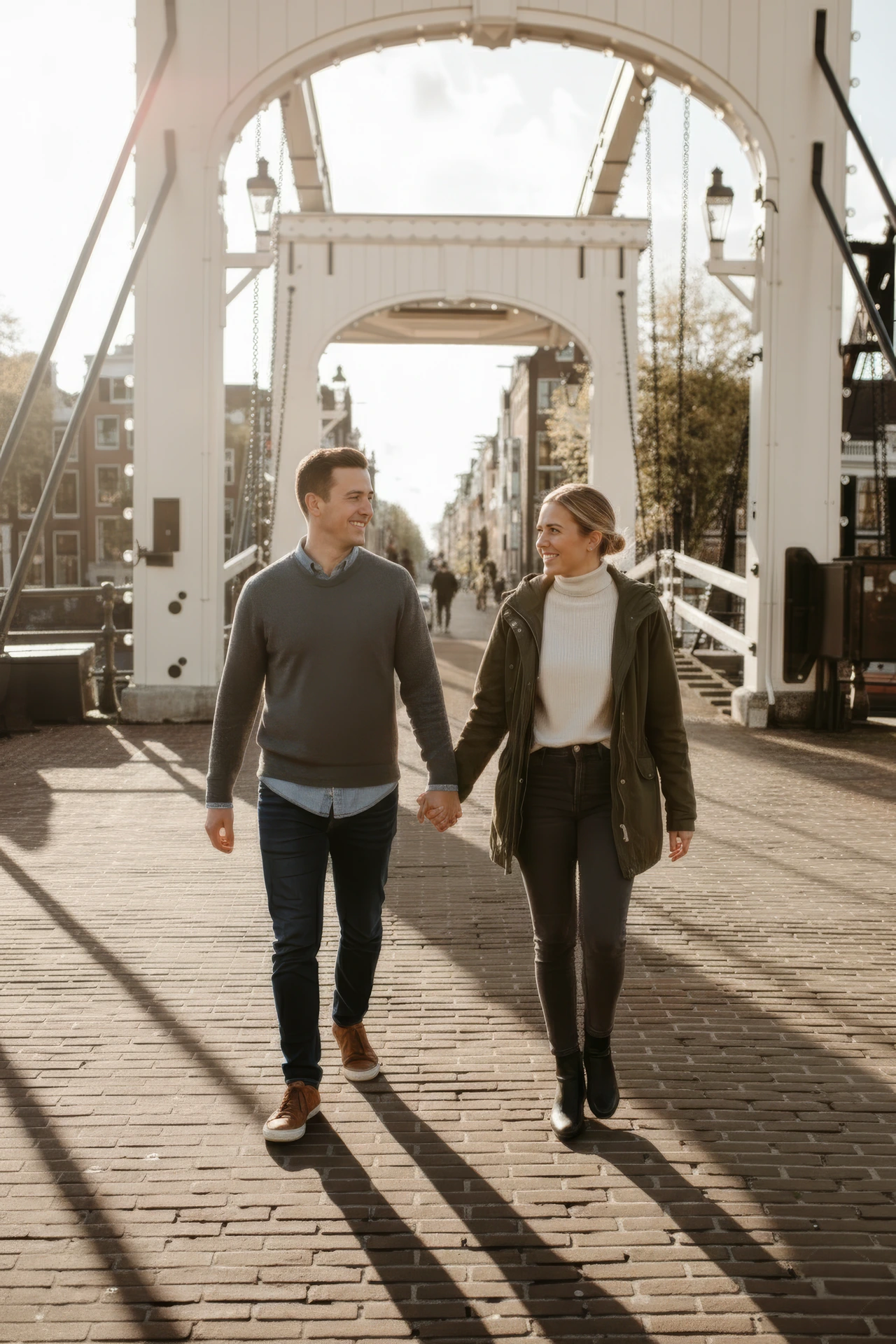 Couple walking at the magere brug during their photoshoot in Amsterdam